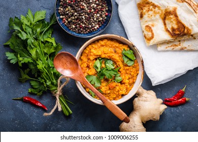 Traditional Indian Lentils Dal, Naan Butter Bread, Fresh Coriander. Indian Dhal Spicy Curry In Bowl, Spices, Herbs, Rustic Concrete Background. Top View. Indian Food. Authentic Indian Dish. Overhead