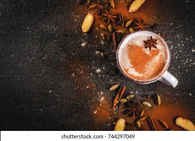 Traditional indian masala chai tea with spices - cinnamon, cardamom, anise, dark stone background. Copy space top view