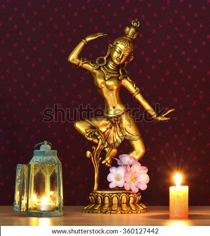 Traditional Indian statue of goddess Tara, the greatest Cosmic power of compassion, illuminated by candle, indoor