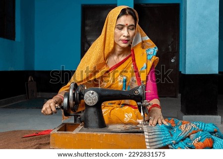 Traditional indian woman housewife wearing sari using sewing machine at home. Skill india Concept.