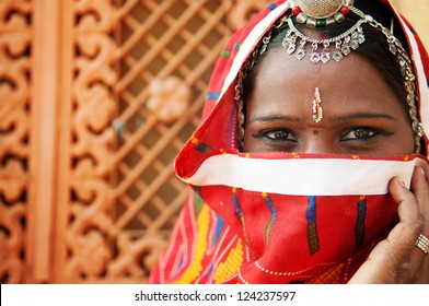 Traditional Indian woman in sari costume covered her face with veil, India