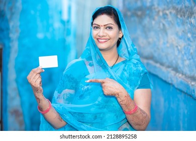 Traditional Indian Woman Showing Blank White Debit Credit Bank Card Mockup, Happy Female Wearing Sari Pointing Holding Empty Business Or Electronic Card For Payment.