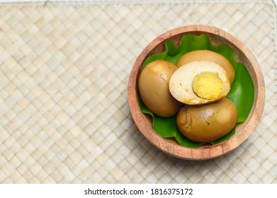 Traditional Indonesian food, known as pindang telur. Served in a traditional bamboo mat and wooden bowl wirh banana leaf. This food is originated from Central Java, Indonesia.  - Shutterstock ID 1816375172