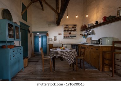 Traditional interior of old village kitchen in historic country house with stucco walls, wooden beams, oak wood furniture, vintage kitchenware - Shutterstock ID 1910630515