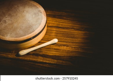 Traditional Irish bodhran and stick on wooden table