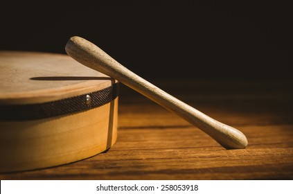 Traditional Irish bodhran and stick on wooden table