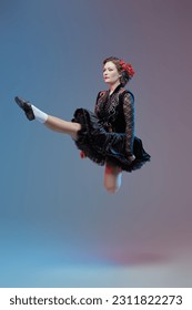 Traditional Irish dances. Beautiful professional dancer woman in national Irish costume makes a high jump during the dance. Studio full-length portrait. - Shutterstock ID 2311822273