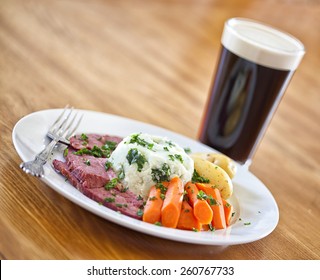 Traditional Irish St. Patricks Day Meal Of Corned Beef, Potatoes And Carrots And A Stout Beer