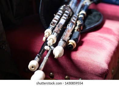 Traditional Irish uilleann pipes (bagpipes) laid out on a vintage pink chair