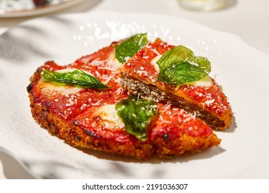 Traditional Italian Dish - Milanese Steak In Breaded And Parmesan On White Ceramic Plate. Milanese Beef With Tomato Sauce And Basil. Italian Beef Steak Alla Schnitzel With Bone. Italian Chop Beef