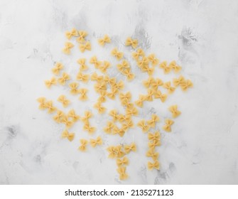 Traditional italian farfalle pasta with on textured wooden background. Bow tie noodles on wood backdrop. Raw organic farfalle noodle