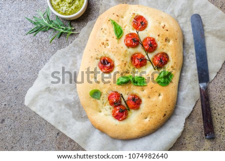 Traditional Italian Focaccia with tomatoes and rosemary - homemade flat bread focaccia, top view