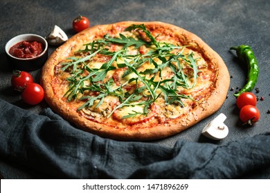 Traditional Italian pizza with arugula and tomatoes on a dark background. - Powered by Shutterstock