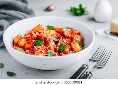 Traditional Italian potato Gnocchi with tomato sauce, parmesan cheese and fresh basil in the bowl - Powered by Shutterstock