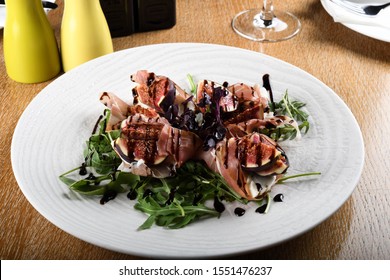 Traditional Italian salad made with figs, Prosciutto dry-cured ham or Parma ham thinly sliced prosciutto cotto served on a white plate in an Italian Restaurant