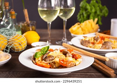 Traditional italian seafood pasta with clams vongole. Two white wine glasses on the background. Romantic or family dinner concept. - Powered by Shutterstock