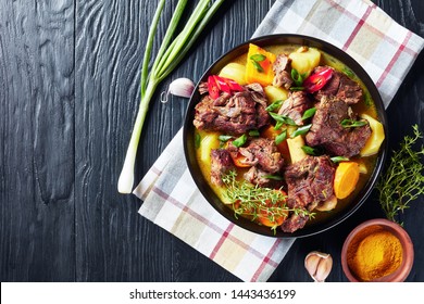 Traditional Jamaican Curry Goat – Slow Cooked Jamaican Spiced Meat And Vegetables Spicy Curry In A Black Bowl On A Rustic Wooden Table, Close-up