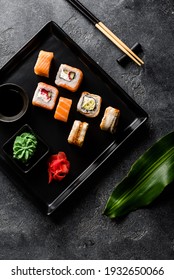 traditional Japanese food fish rolls on black stone background flat lay 