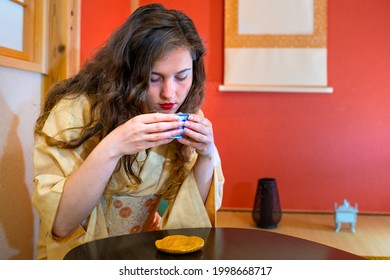 Traditional Japanese Kimono Costume With Foreigner Caucasian Woman Girl Sitting By Alcove Hanging Paper Scroll Drinking Green Tea In Ceremony