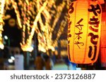 Traditional Japanese Lanterns are used to decorate the front of street food restaurants along Sendai Park. The translation text says " Yakitori or grilled chicken" a type of Japanese food.