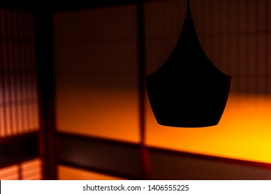 Traditional Japanese Machiya House Or Ryokan Restaurant With Hanging Lamp And Dark Evening Night Background Of Shoji Sliding Paper Door With Orange Light