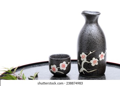 Traditional Japanese sake cup and bottle on white background 