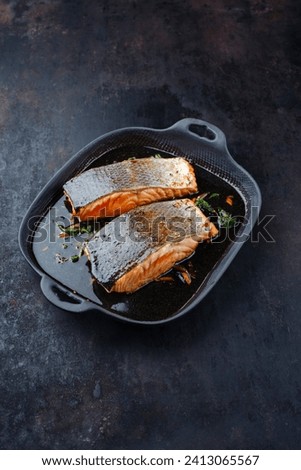 Traditional Japanese salmon fish teriyaki filet with soy souce and spinach as top view in a Nordic design pan with copy space 