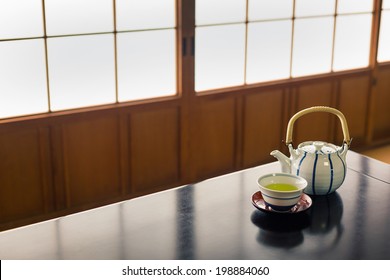 A Traditional Japanese Scene With A Pot And Cup Of Green Tea