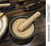 A traditional Japanese sesame grinding tool featuring a ceramic bowl called 