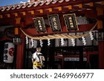 Traditional Japanese shrine with festival attire. The meaning of 波上宮 in English is Naminoue Shrine. The meaning of 萬民泰平、國家鎮戶 in English is Peace for all people, national towns and households.