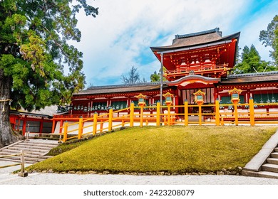 Traditional Japanese style building in a blur foreground of trees in Kasuga Taisha, Nara, Japan - Powered by Shutterstock