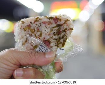 Traditional Japanese style  rice ball  in woman hand , foreign language  円 means  Yen ,  税込  means tax included

