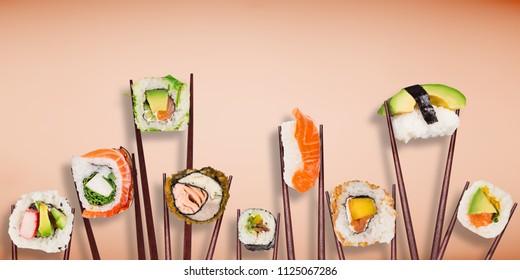 Traditional japanese sushi pieces placed between chopsticks on pastel color background. Very high resolution image.