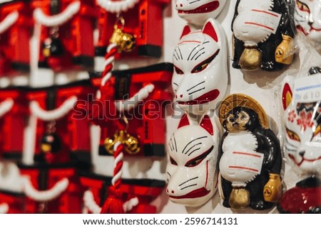 Traditional Japanese tourist souvenirs and gifts from Kyoto, Kansai, Japan, with daruma figures, kitsune fox, tengu mask, fridge magnets, toys figurines, key ring keychain, in a local vendor gift shop