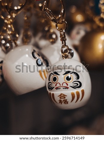Traditional Japanese tourist souvenirs and gifts from Kyoto, Kansai, Japan, with daruma figures, kitsune fox, tengu mask, fridge magnets, toys figurines, key ring keychain, in a local vendor gift shop