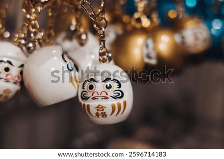 Traditional Japanese tourist souvenirs and gifts from Kyoto, Kansai, Japan, with daruma figures, kitsune fox, tengu mask, fridge magnets, toys figurines, key ring keychain, in a local vendor gift shop