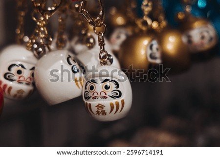 Traditional Japanese tourist souvenirs and gifts from Kyoto, Kansai, Japan, with daruma figures, kitsune fox, tengu mask, fridge magnets, toys figurines, key ring keychain, in a local vendor gift shop