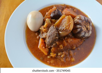 Traditional Jewish stew,  (Cholent Hamin) served in a plate on Sabbath Day. Food background and texture. No people. Copy space