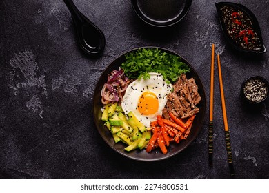 Traditional Korean dish Bibimbap: rice with vegetables beef and egg, top view.