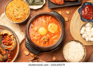 Traditional Korean food, kimchi soup, Korean Fried chicken with spicy sauce  with rice, seaweed,fresh raw crabs marinated,spicy Rice Cake and Kimchi pickle on wooden table. - Shutterstock ID 2101105579
