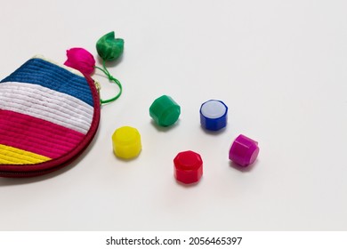 Traditional Korean game kit Gonggi. Colourful plastic stones with rainbow colored pouch isolated on white background.
