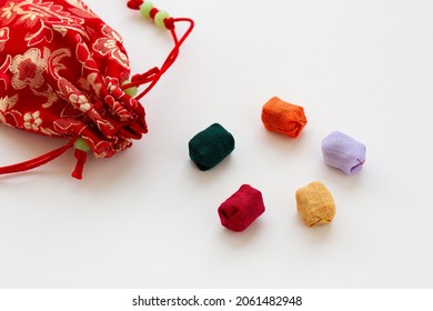 Traditional Korean game kit Gonggi. Colourful ramie wrapped plastic stones with pouch isolated on white background.
