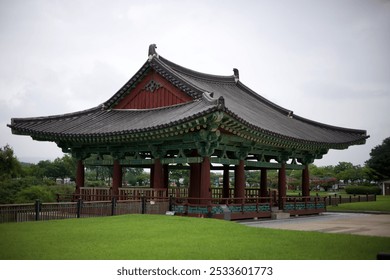 A traditional Korean pavilion located in a lush green park on a cloudy day. - Powered by Shutterstock