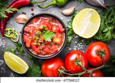 Traditional Latin American Mexican  Salsa Sauce And Ingredients On Black Stone Table. Top View.