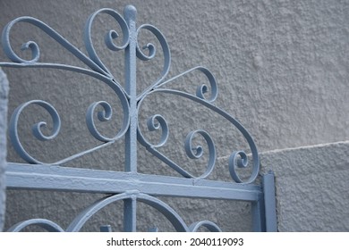Traditional light blue handcrafted wrought iron entrance gate railing against a whitewashed textured wall in Galaxidi, Phocis Greece. 