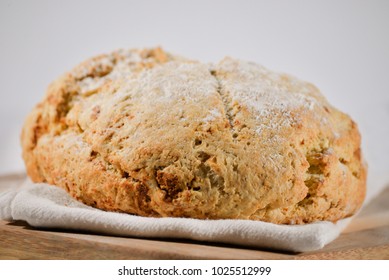 Traditional Loaf Of Round Irish Soda Bread  With Flour Sprinkled On Top, Perfect Of St. Patrick's Day Meal Served With Corned Beef, Cabbage, Potatoes, Carrots, Sweet Corn, And Dark Guiness Beer.