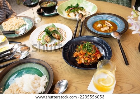 Traditional local cuisine set thai fusion food served on table with cutlery set or flatware tableware in modern dining room for guest customer eat drinks at luxury restaurant cafe in Bangkok, Thailand
