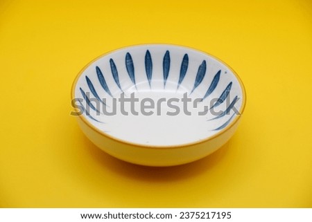 traditional luxury utensil dine ware Japanese ceramic china blue art design round big small gloss plate bowl with spoon and chopstick on yellow background