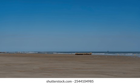 Traditional Malagasy pirogue on the ocean at low tide. Waves are foaming next to a wooden weathered boat. A ship is on the horizon. Clear blue sky. Copy space. Madagascar. Morondava.  - Powered by Shutterstock