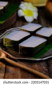 Traditional Malaysian Deasert Called Kuih Tepung Pelita Or Kuih Tako On A Rustic Plate Over A Dark Background. Coconut Milk And Flour Prepared In Banana Leaves. Popular During Fasting Month Ramadan